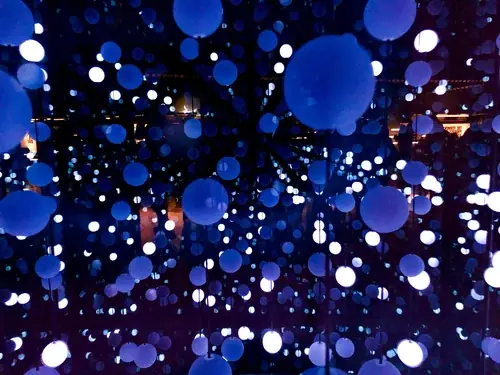 Blue and white illuminated spheres filling a dark room