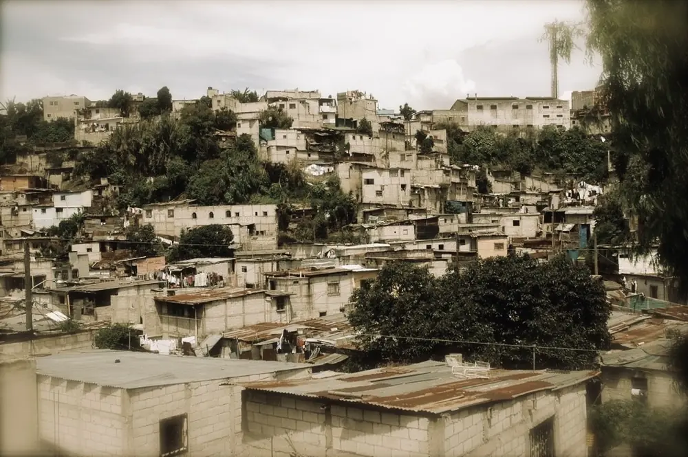 Hillside neighborhood of stacked concrete houses under a grey sky