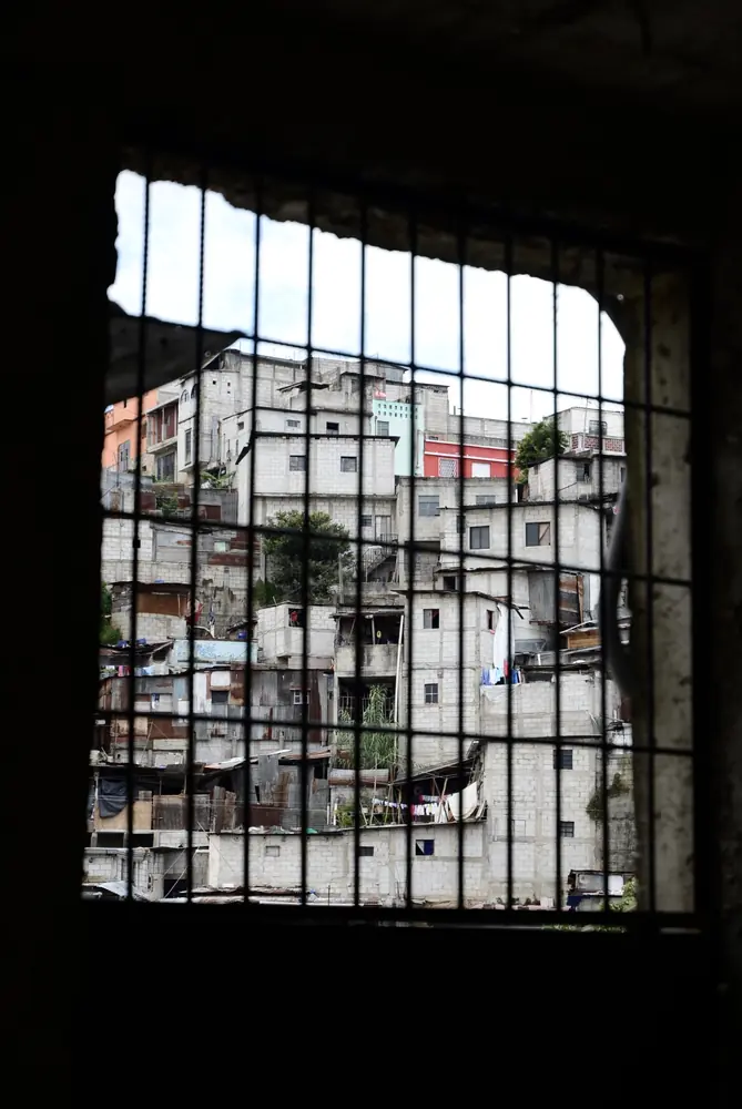 Barred window looking out over a dense hillside settlement