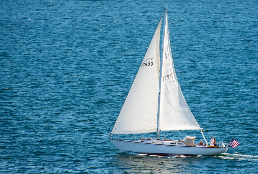 Sailboat under full sail on open blue water