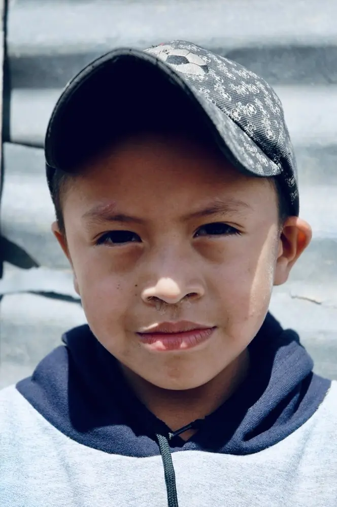 Boy in a camouflage cap and grey hooded sweatshirt