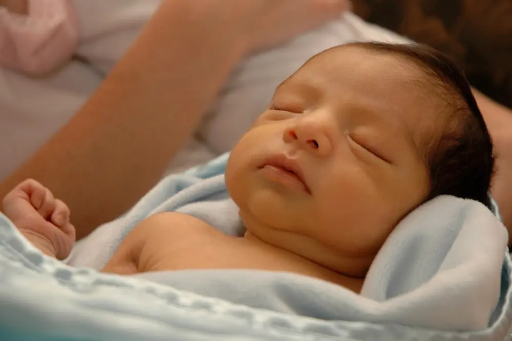 Newborn sleeping wrapped in a blanket