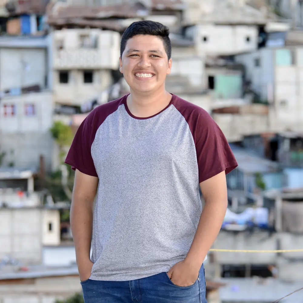 Young man standing above a dense hillside city