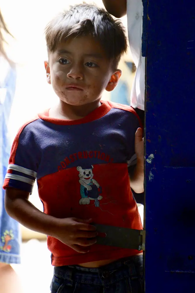 Boy leaning against a blue painted post