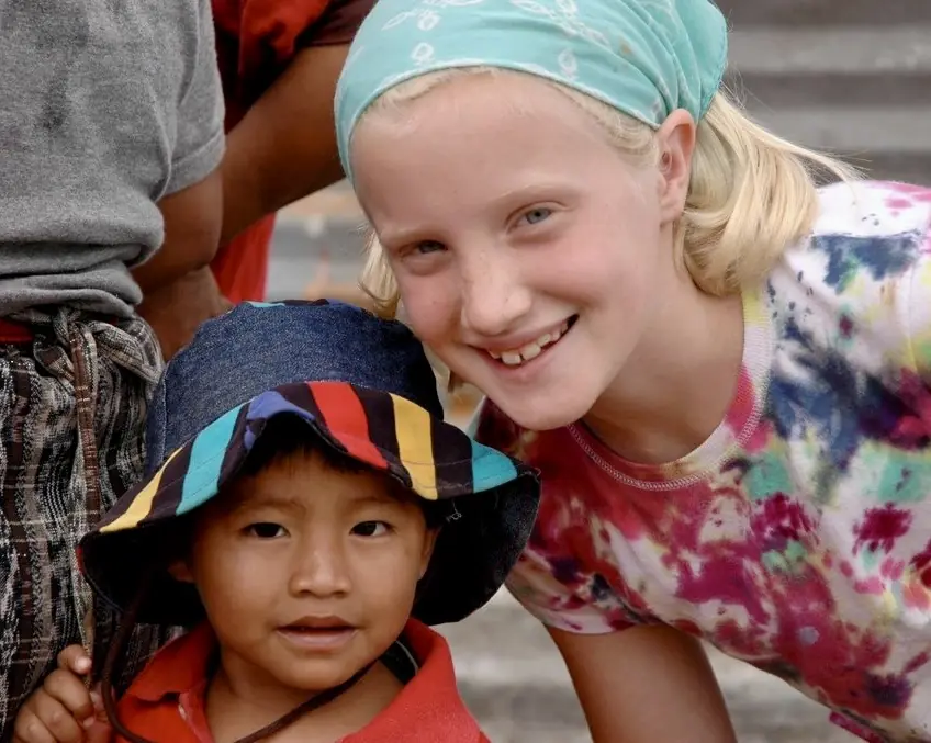 Girl in a headband with a younger boy in a bucket hat