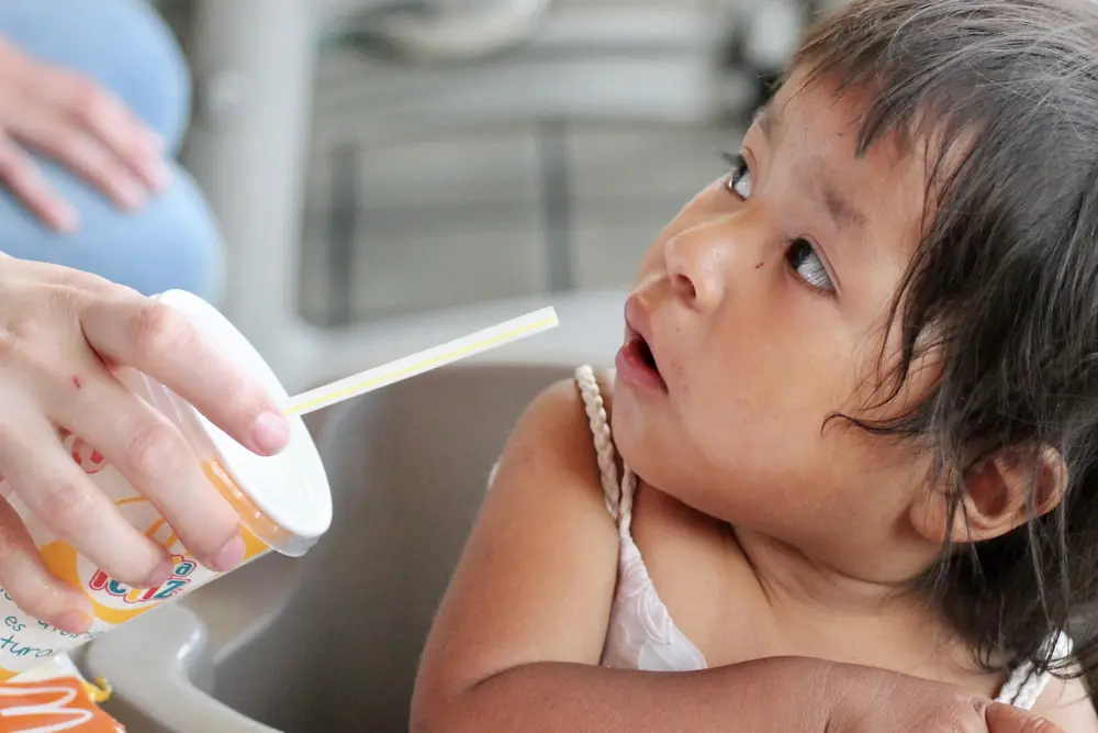 Small child being offered a drink